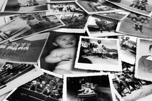 Viele alte private schwarz-weiß Fotos auf einem Tisch